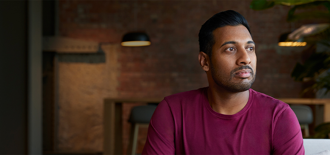 Amar 坐在室内，看向自己的左侧。