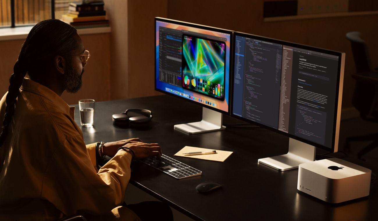Un profesional trabaja con un Mac Studio y dos monitores Studio Display