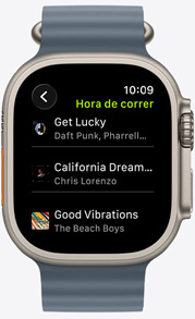 La pantalla de un Apple Watch muestra una playlist de Fitness+ con canciones de The Weeknd, Skrillex, Justin Bieber y Shawn Mendes