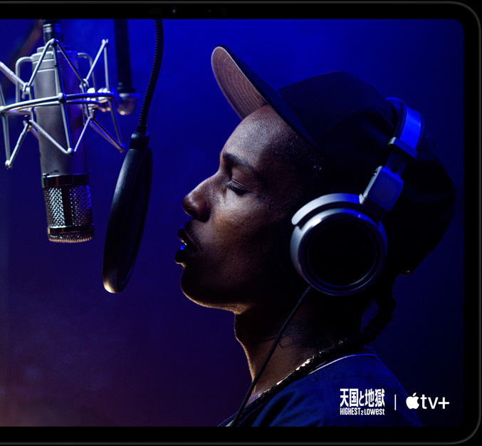 iPad Proの前面の外観、横向き、カラーはスペースブラック、丸みを帯びた四隅、ブラックのディスプレイベゼル。ディスプレイにApple TV+のオリジナル映画「天国と地獄」の一場面が表示されている。Yung Felon役のエイサップ・ロッキーがマイクに向かってラップしている