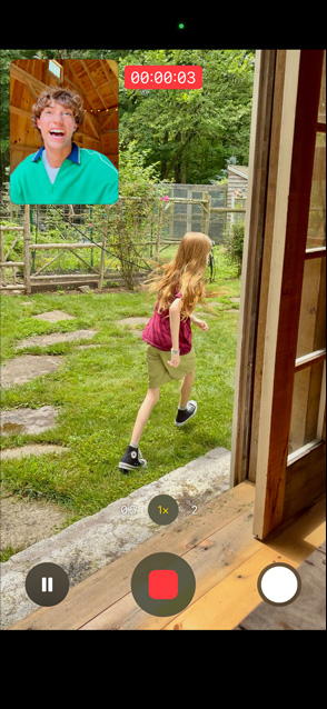 Pantalla de un iPhone 17 que usa la Captura Dual para grabar con la cámara trasera a una niña corriendo y con la cámara frontal a un hombre mirándola