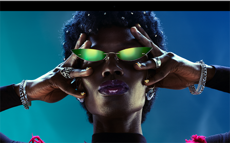 شاشة ملونة على MacBook Pro تُظهر شخصاً يتفاعل بحماس مع الجمهور في إحدى الحفلات، ما يبرز حيوية شاشة ريتنا ليكويد XDR النابضة بالحياة