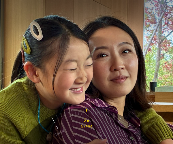 Funcția Teleobiectiv 2x activată, zoom-in pe două persoane îmbrățișate