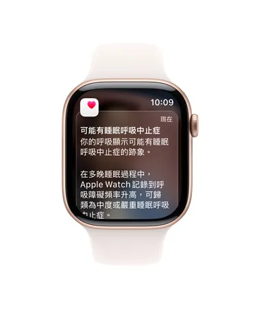 Apple Watch Series 11，展示玫瑰金色鋁金屬錶殼，搭配淡胭粉色運動型錶帶，螢幕顯示完整呼吸中止症通知，機身右側展示數位錶冠