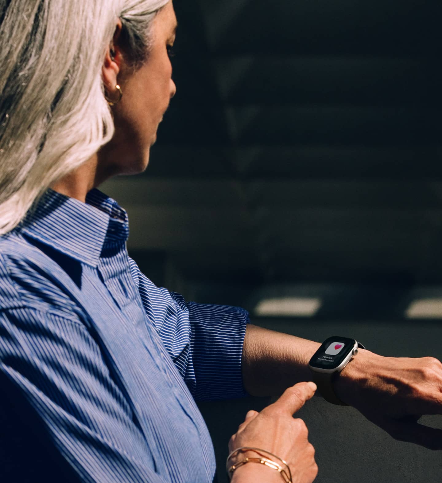 Iemand leest een melding over een mogelijk hoge bloeddruk op een Apple Watch Series 11