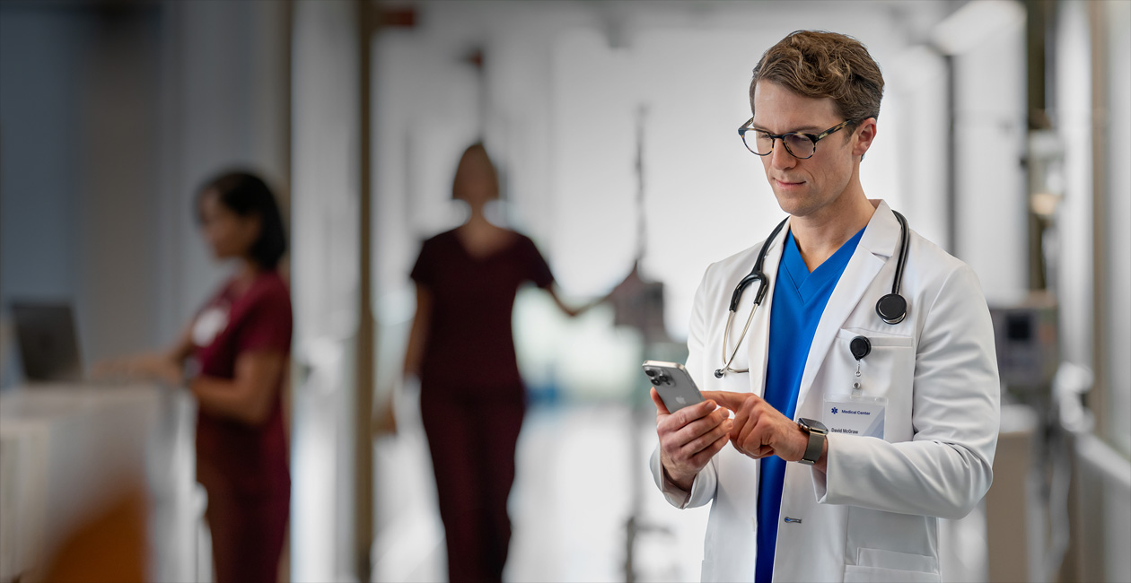 Un médecin consulte son iPhone dans un hôpital.